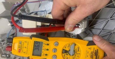 Checking an appliance component with a multimeter during diagnosis