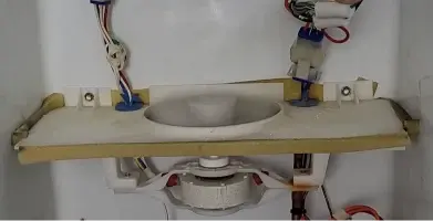 Technician checking the cooling components behind a refrigerator panel